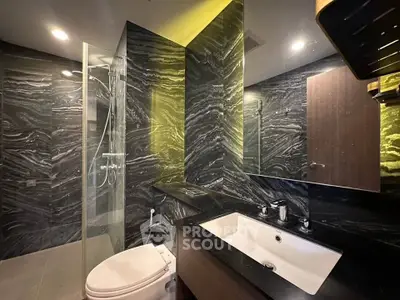Luxurious modern bathroom with sleek black marble walls and elegant fixtures.