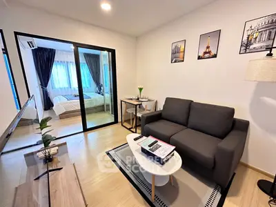 Modern living room with cozy sofa and view into stylish bedroom