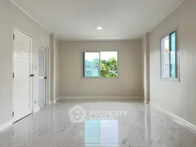 Spacious empty room with large windows and glossy tiled floor, perfect for customization.