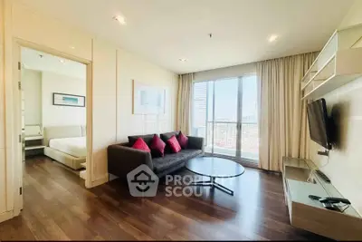 Spacious modern living room with city view, featuring sleek furniture and natural light.
