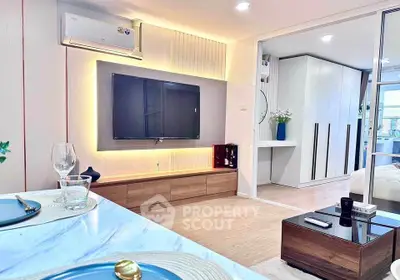 Modern living room with stylish decor and open layout, featuring a large TV and elegant dining setup.