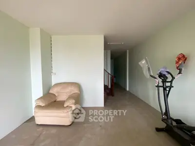 Spacious interior with exercise equipment and cozy seating area, ideal for home gym setup.