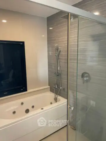 Modern bathroom with sleek bathtub and glass shower enclosure