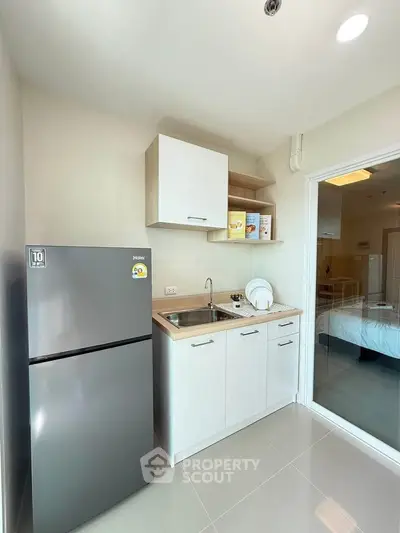 Modern compact kitchen with sleek appliances and ample storage in a cozy apartment