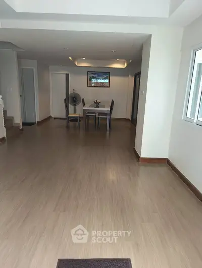 Spacious open-plan living area with dining table and modern flooring