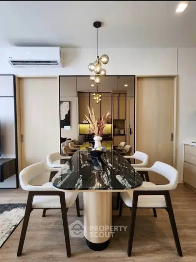 Modern dining area with elegant marble table and stylish lighting in a contemporary apartment.
