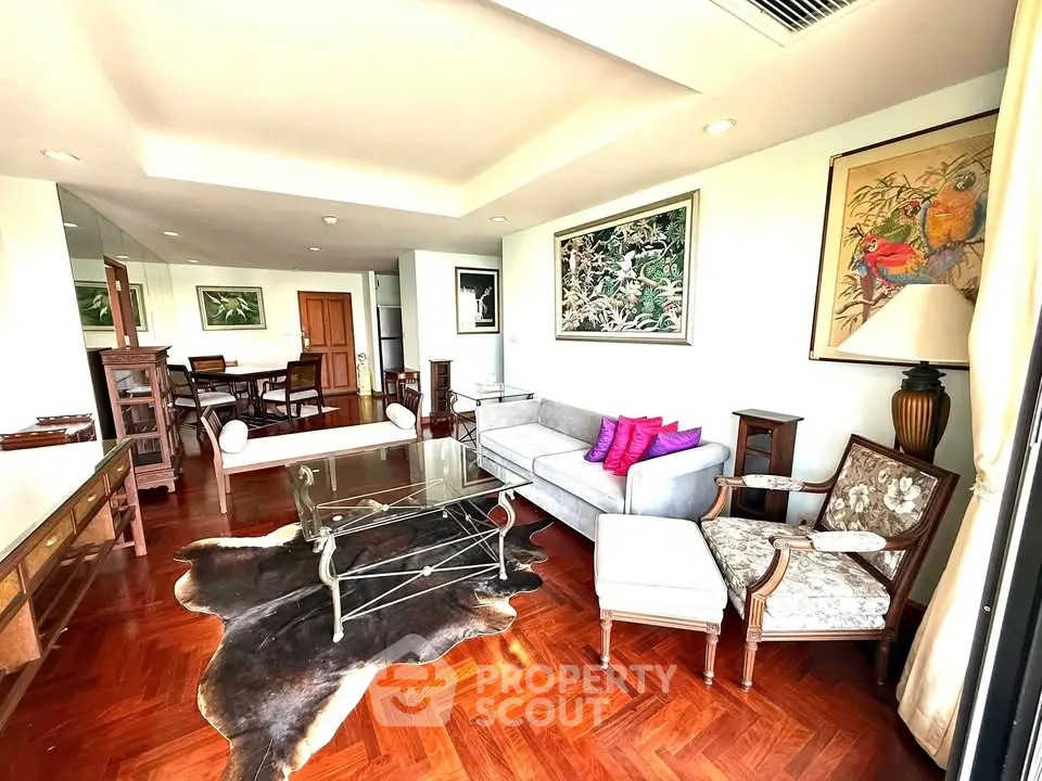 Elegant living room with hardwood floors, stylish furniture, and vibrant artwork.