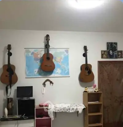 Cozy room with guitars on wall, perfect for music lovers.