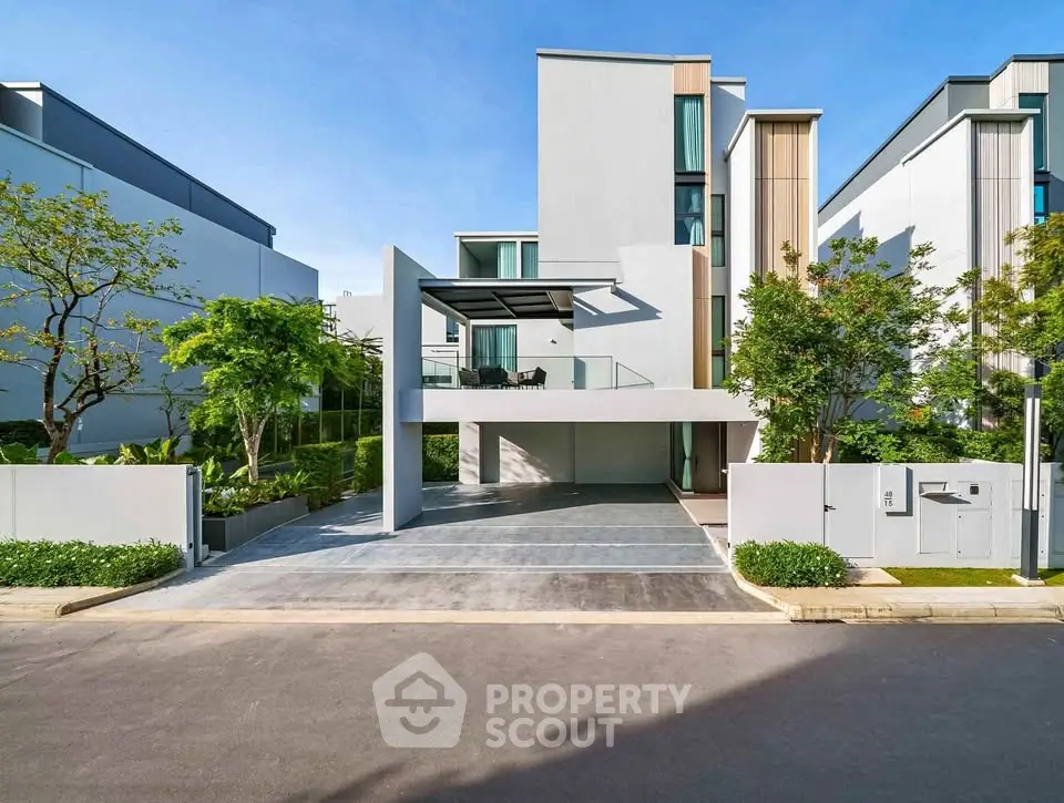 Modern luxury home with sleek design and spacious driveway in a serene neighborhood.