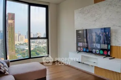 Modern living room with city view, featuring a sleek TV setup and stylish decor.