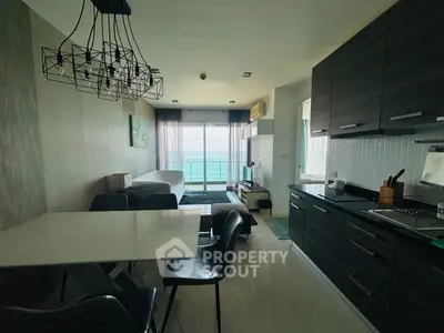 Modern open-plan living room with ocean view, sleek kitchen, and stylish dining area.