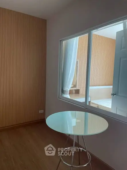 Modern room with glass table and wooden panel walls