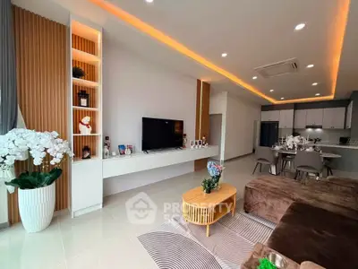 Modern living room with open kitchen, stylish decor, and cozy seating area.