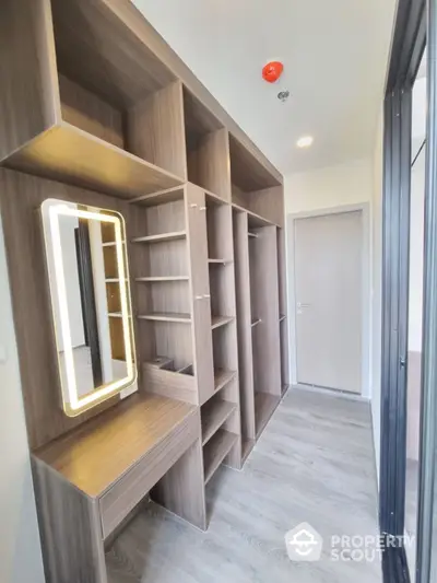 Modern walk-in closet with wooden shelves and illuminated mirror