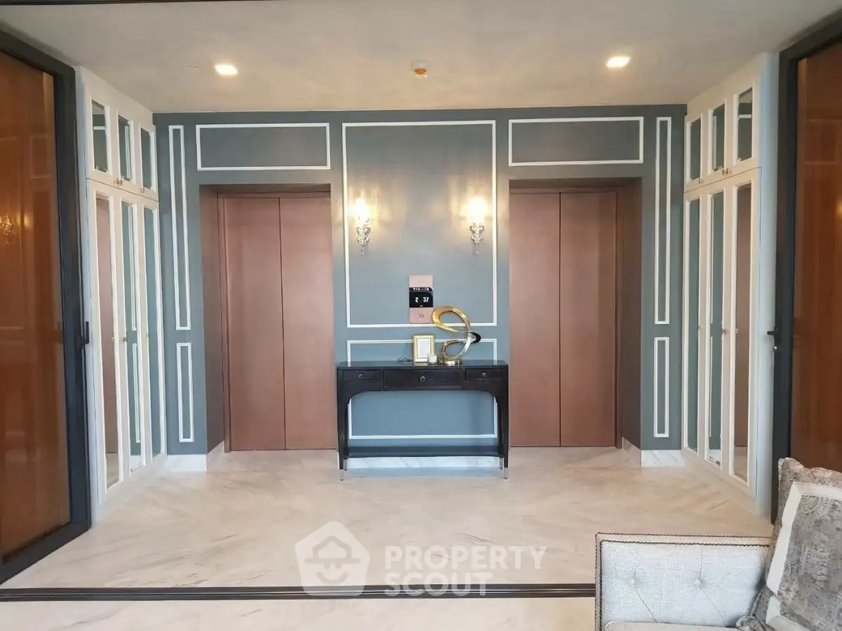 Elegant building entrance with dual elevators and stylish decor