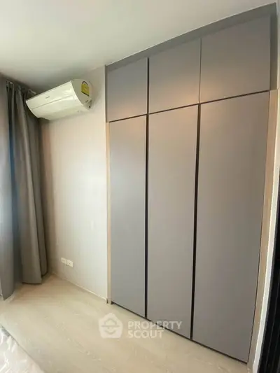 Modern bedroom with sleek wardrobe and air conditioning unit