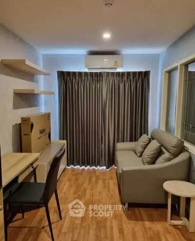 Modern living room with sleek furniture and wooden flooring, featuring a cozy sofa and a study area.