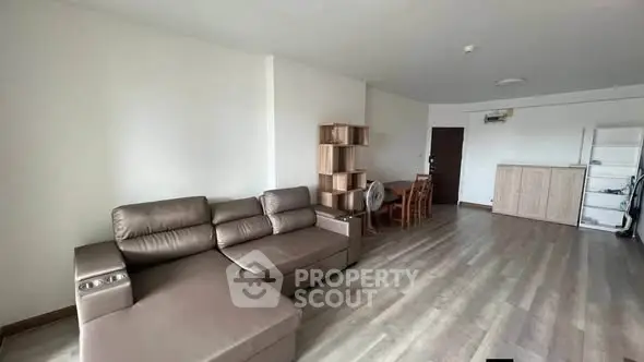 Spacious living room with modern furniture and wooden flooring in a contemporary apartment.