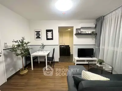 Modern living room with stylish decor and open layout, featuring a cozy dining area and sleek TV setup.