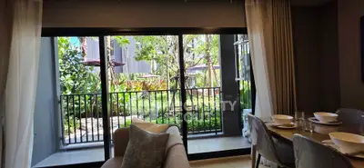 Spacious living room with garden view through large sliding glass doors, perfect for relaxation.