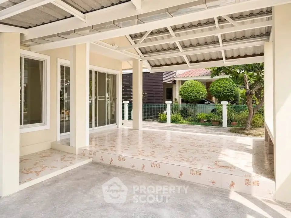 Spacious covered patio with tiled flooring and garden view in modern home