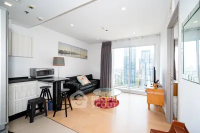 Modern living room with city view, featuring sleek furniture and open layout.