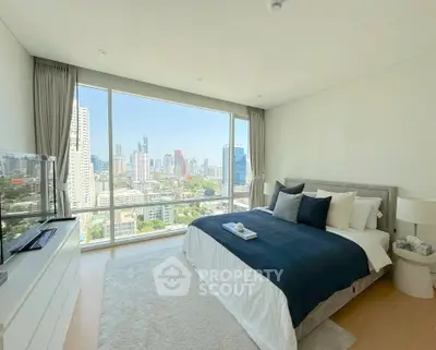 Luxurious bedroom with stunning city view, featuring modern decor and large windows for natural light.