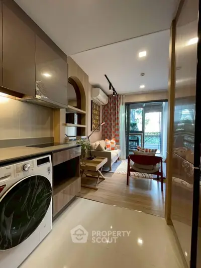 Modern open-layout kitchen and living room with stylish decor and natural light.