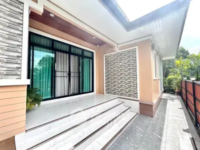 Charming modern home entrance with stylish tiled steps and lush greenery.