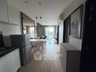 Modern open-plan living room with kitchen and dining area, featuring sleek design and city view.