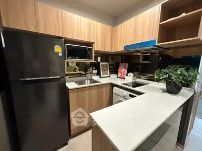 Modern kitchen with sleek appliances and wooden cabinetry in a stylish apartment.