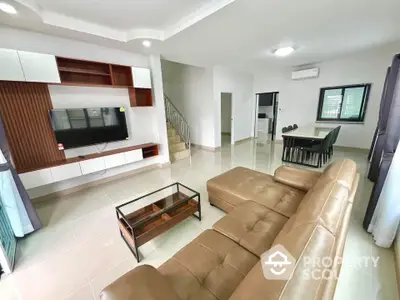 Spacious modern living room with leather sofa and open dining area