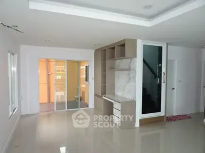 Spacious modern living room with sleek built-in shelving and large windows.