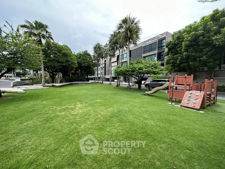 Spacious green garden with playground in modern residential complex