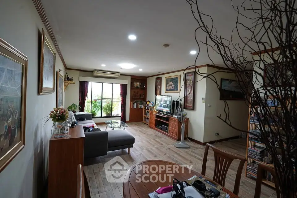Spacious living room with modern decor and large window offering natural light.