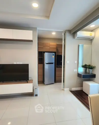 Modern living room with sleek furniture and integrated kitchen area in a stylish apartment.