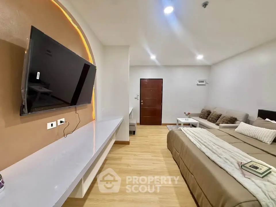 Modern studio apartment with cozy living area and wall-mounted TV