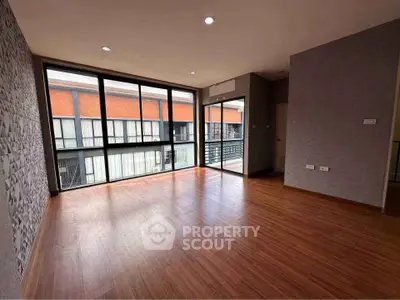 Spacious modern living room with large windows and wooden flooring