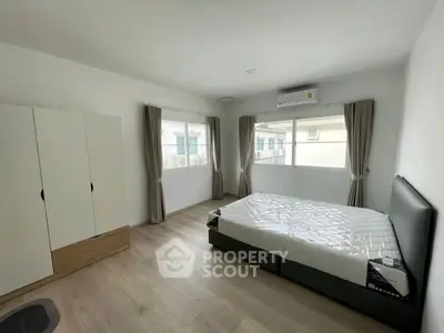 Spacious bedroom with modern furnishings and natural light in a stylish apartment.