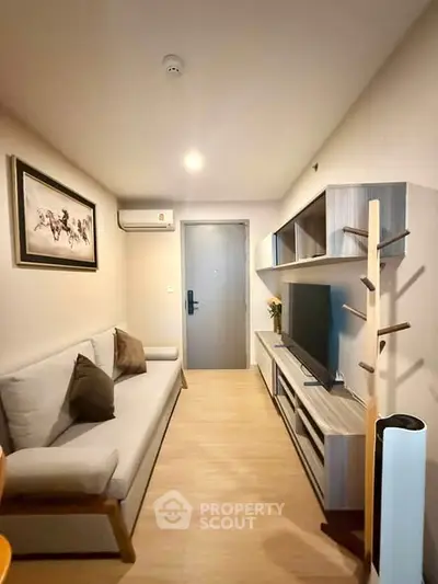 Modern living room with stylish furniture and wall art, featuring a cozy sofa and entertainment unit.