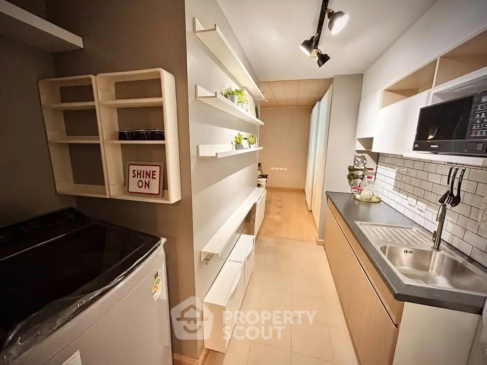 Modern kitchen with sleek design, featuring open shelving and built-in microwave, perfect for urban living.