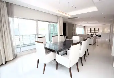 Spacious modern dining area with elegant table and chairs, large windows, and open layout.