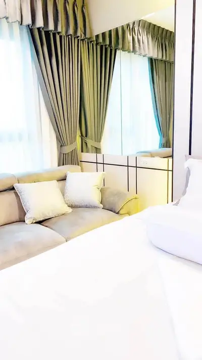 Elegant bedroom with plush sofa and stylish curtains, perfect for relaxation and comfort.