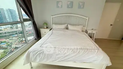 Modern bedroom with city view, featuring a cozy bed and stylish decor in a high-rise apartment.