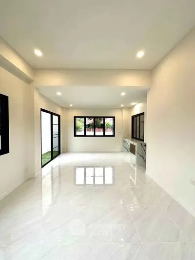 Spacious open-plan living room with large windows and modern design