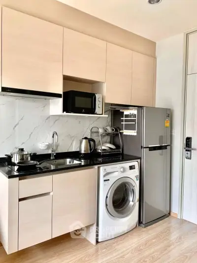 Modern compact kitchen with appliances including fridge, washing machine, and microwave in sleek design.