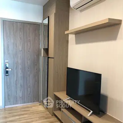 Modern apartment interior with TV, wooden flooring, and air conditioning