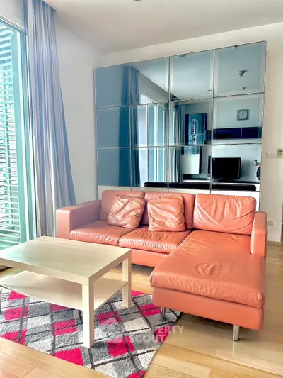 Modern living room with stylish orange sofa and mirrored wall cabinets