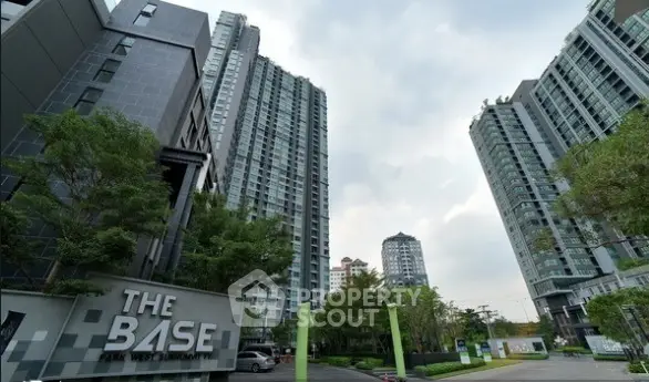 Modern high-rise condominium buildings with lush green surroundings and clear sky.