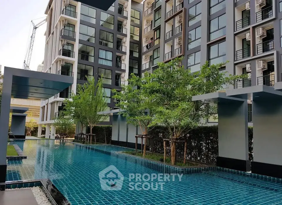 Modern condominium with pool and lush greenery, offering a serene urban living experience.